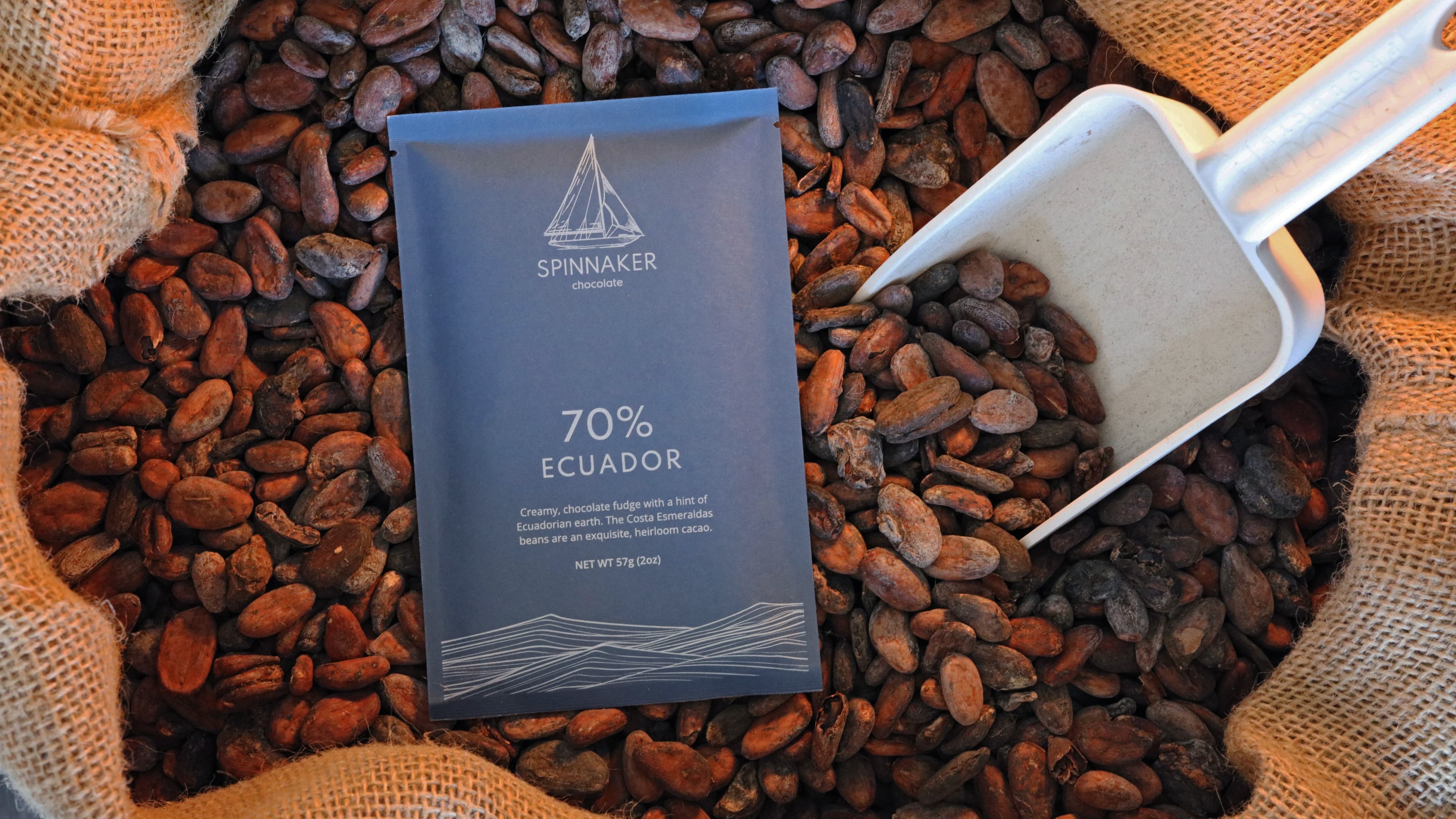 70% Ecuador bar made by Spinnaker Chocolate in the United States with in a bag of cacao beans with a scooper