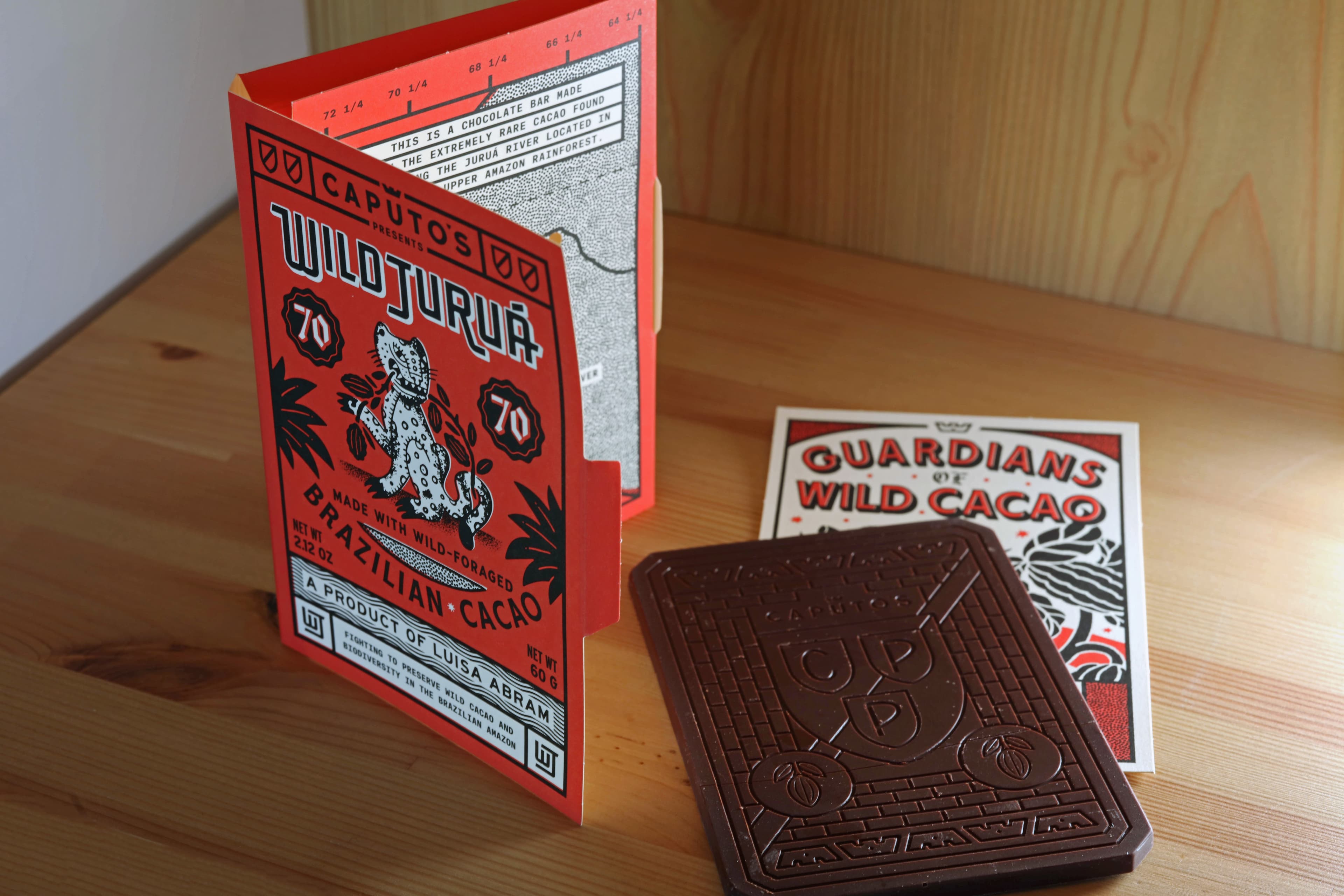 Caputo's Wild Jurua 70% bar by Luisa Abram made with Caputo's Market & Deli in Brazil with the packaging standing open and the postcard visible