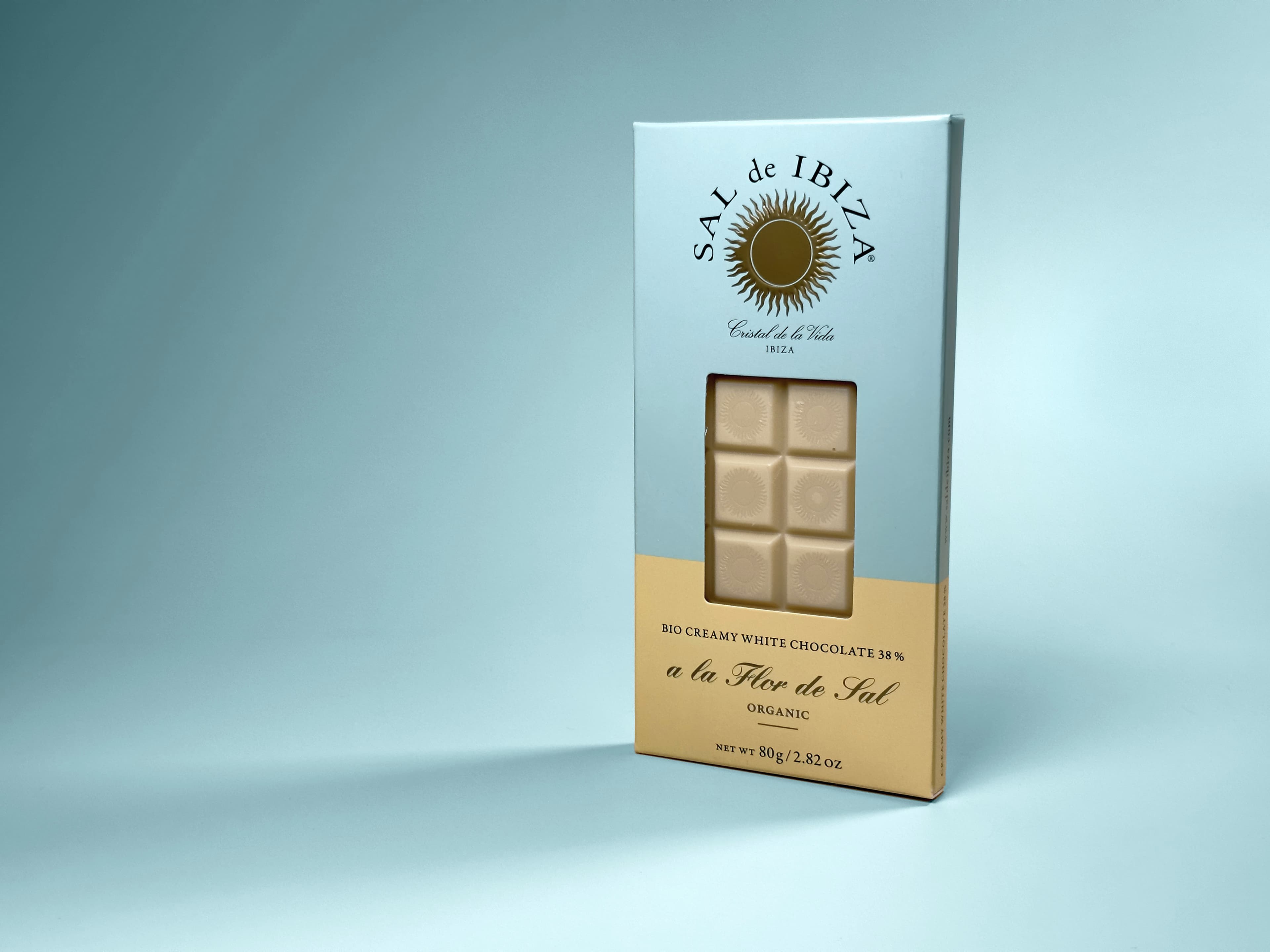 Creamy White Chocolate 38% a la Flor de Sal bar from SAL de IBIZA standing up with a blue background