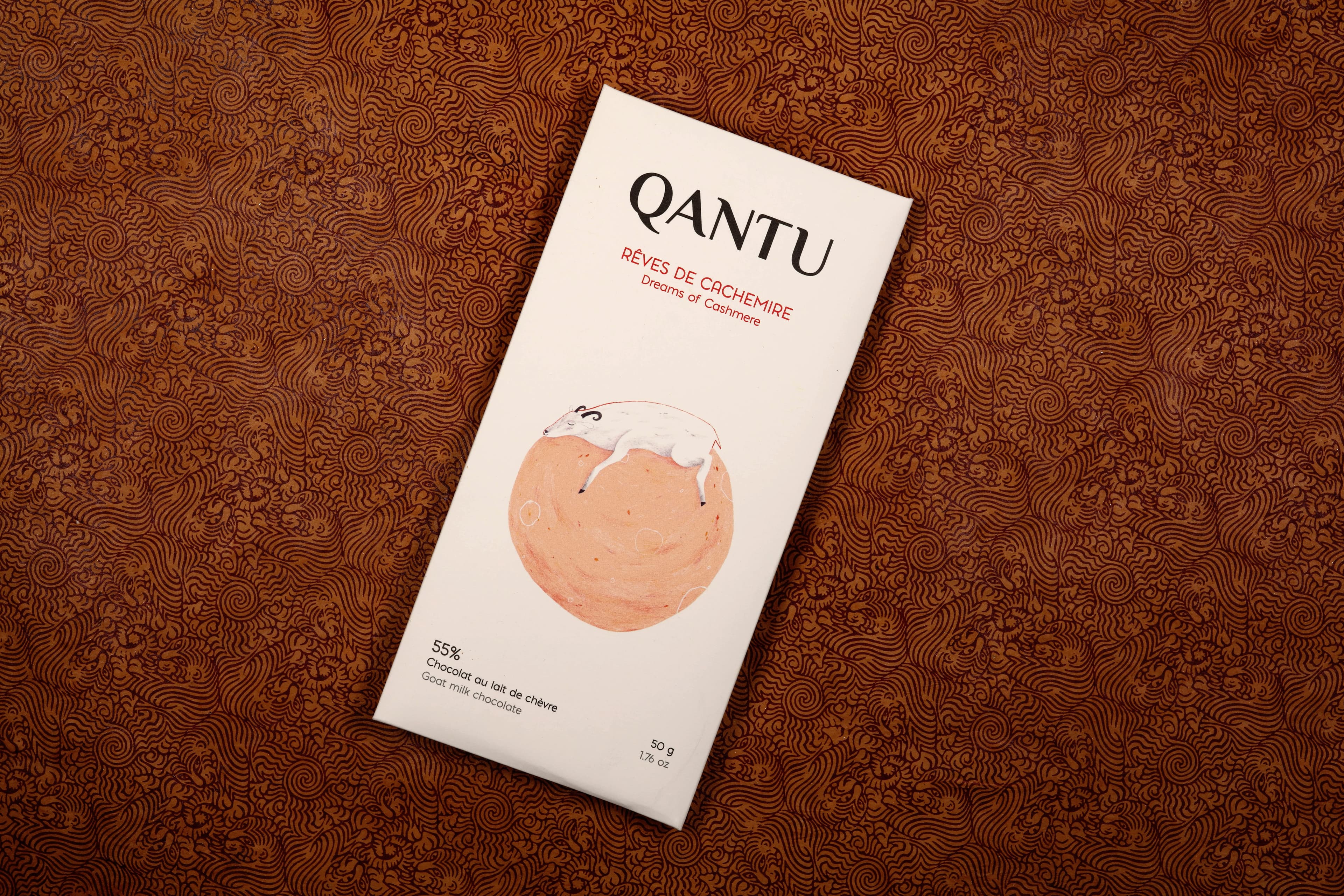 Dreams of Cashmere Goat Milk Chocolate bar made by Qantu in Canada on a orange patterned background
