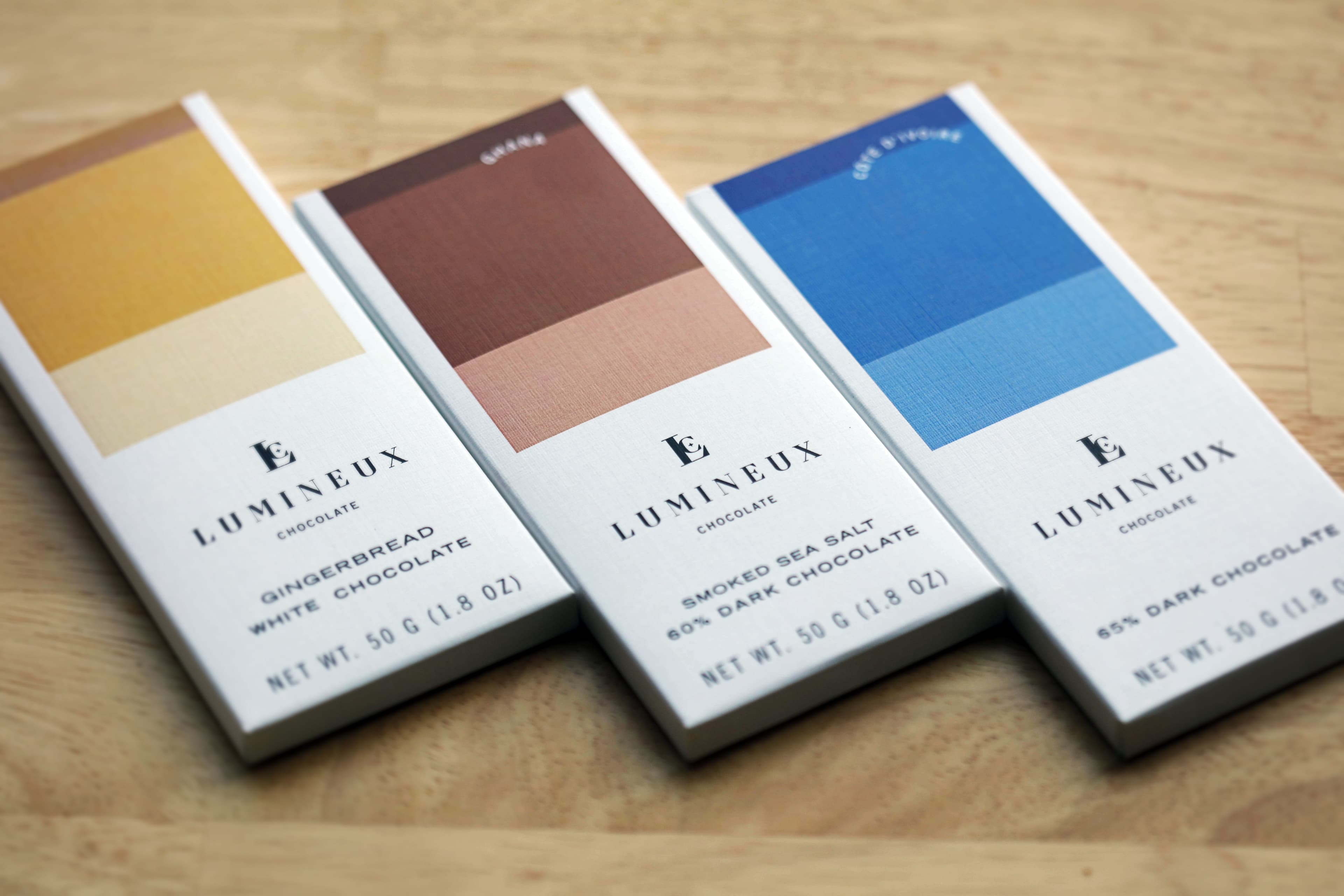 Smoked Sea Salt 60% Dark Chocolate bar made by Lumineux Chocolate in the United States on a on a table with other Lumineux bars