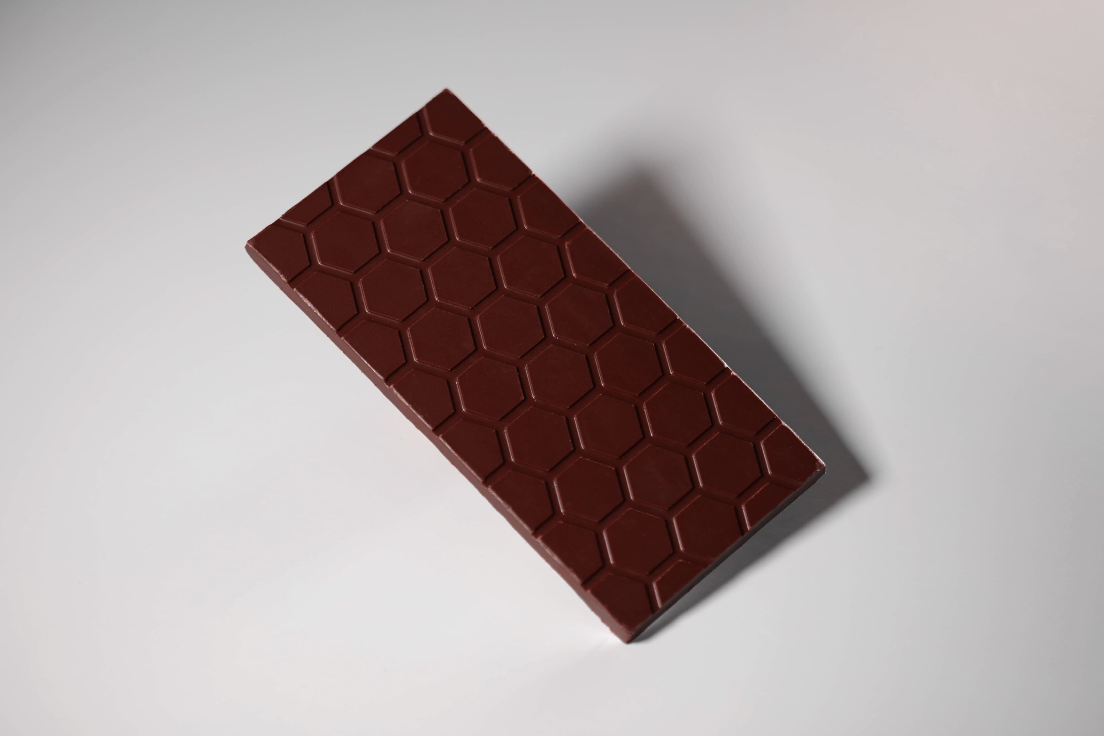 Strawberry Milk Chocolate bar made by Honeymoon Chocolates in the United States floating on a gray background