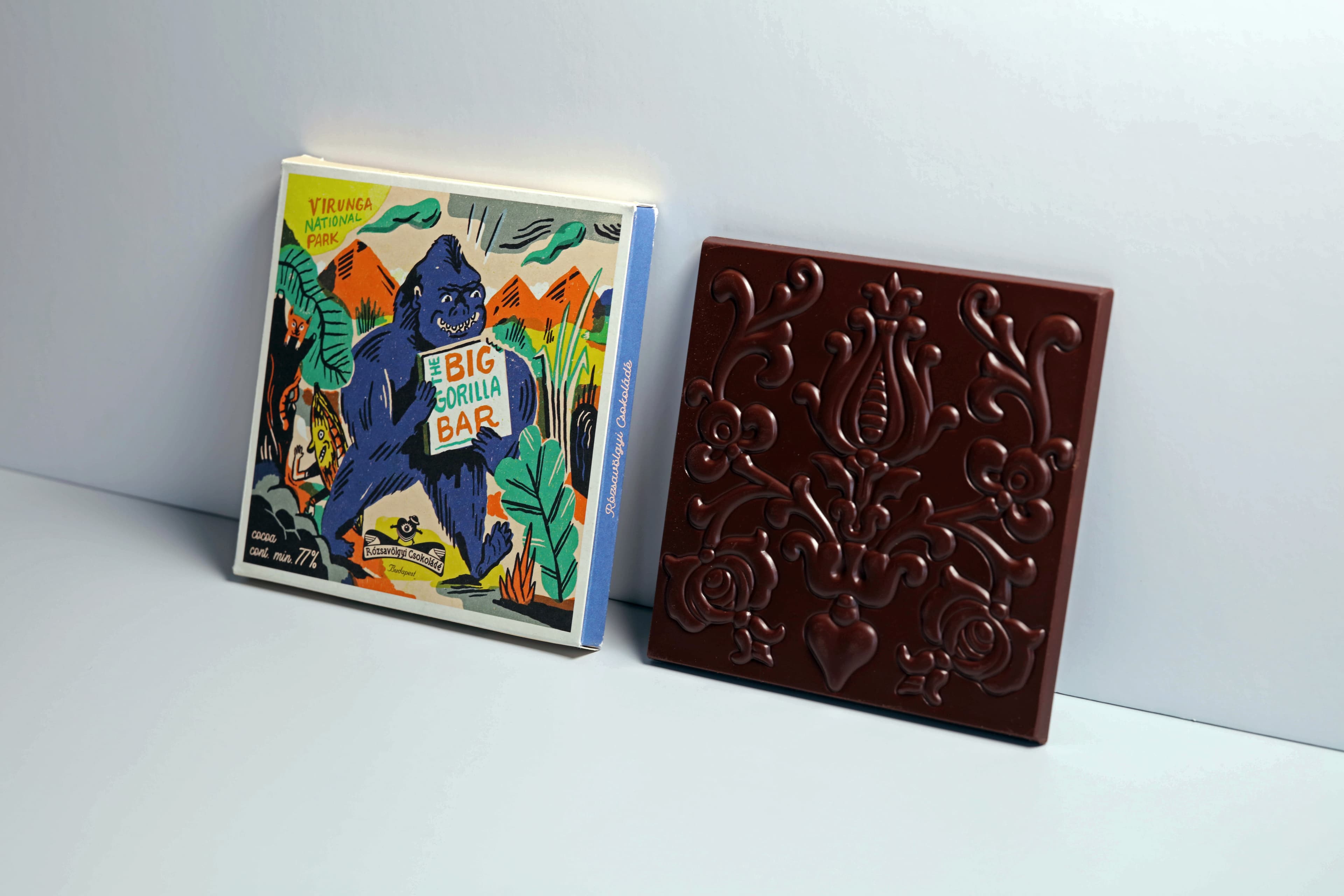 The Big Gorilla Bar Virunga Congo 77% bar made by Rózsavölgyi Csokoládé in Hungary with leaning against a wall next to the packaging