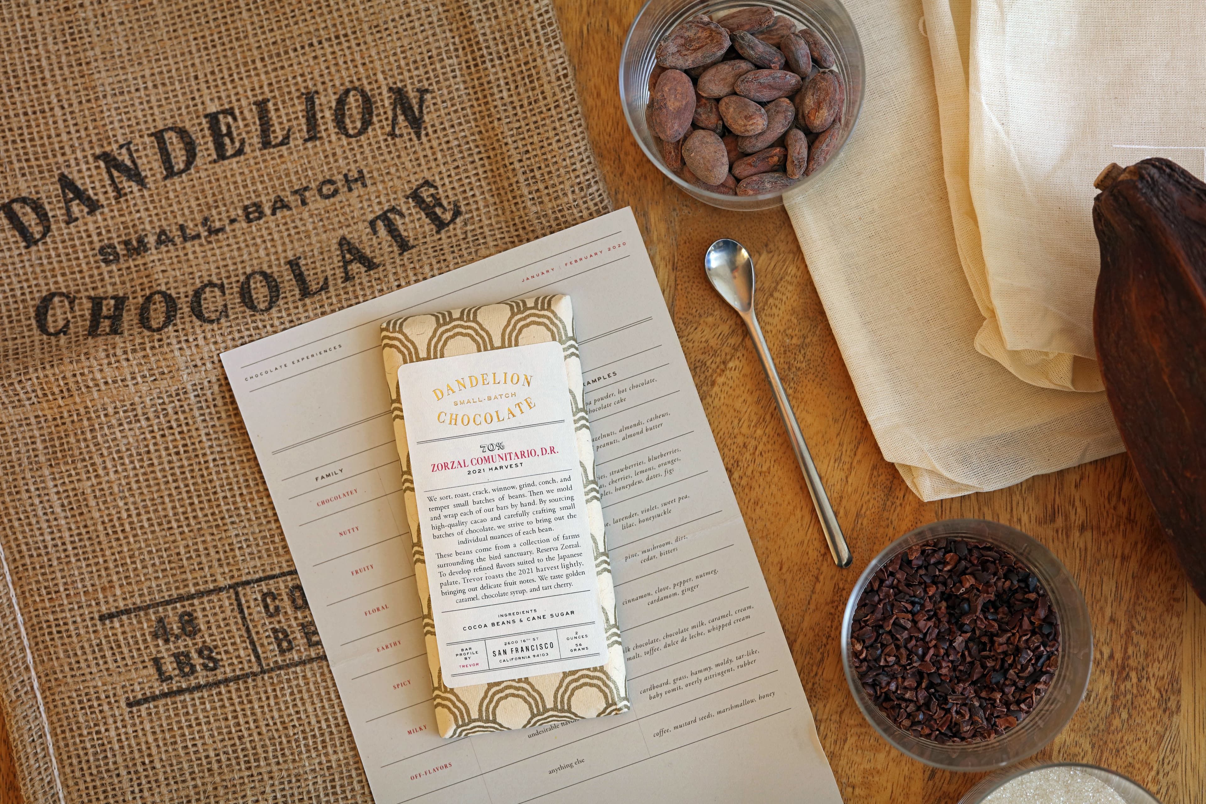 Zorzal Comunitario Dominican Republic 2021 Harvest bar made by Dandelion Chocolate in the United States with other dandelion branded materials like bags, tasting notes, sugar and cocoa nibs